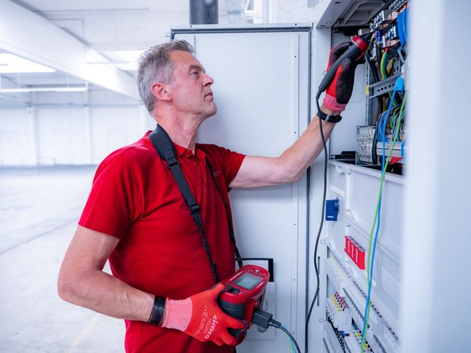Elektriker von Eulektra prüft mit einem Messgerät die Elektroinstallation in einem Schaltschrank